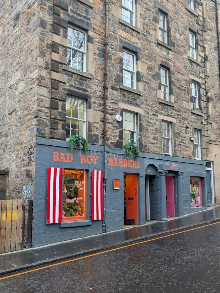 Bad Boy Barbers shopfront beneath the Old Town tenements on Candlemaker Row